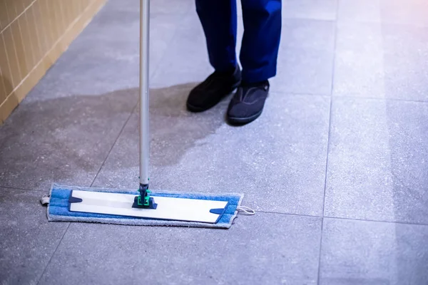 Selective focus to mop to clean floor surface. Cleaning floor with mop. The concept of cleaning service.