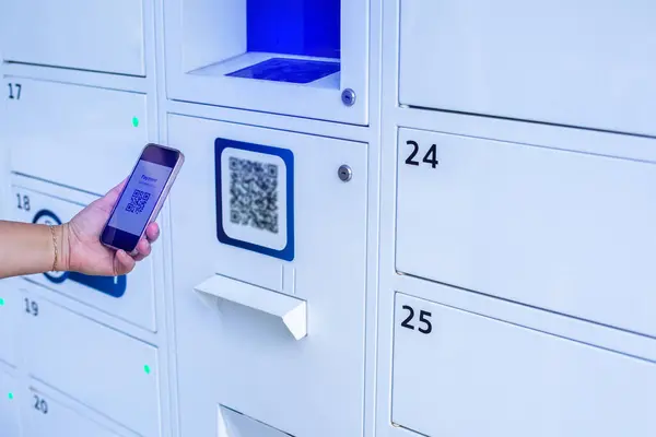 Selective focus to hand holding smartphone to scanning QR code on tag.  Scanning QR code to pay for the storage locker rental. Customer  payment to accepted generate digital pay without money.