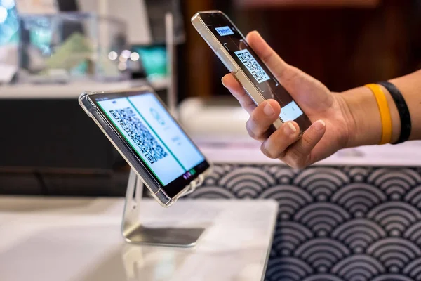 Selective focus to Smartphone in hand to scan QR code payment tag in restaurant to accepted generate digital pay without money. Qr code payment concept.