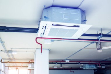 Yangın fıskiyeli su boruları ve havalandırma sisteminin diğer bölümleriyle birlikte kaset tipi hava durumu birimlerine odaklan..