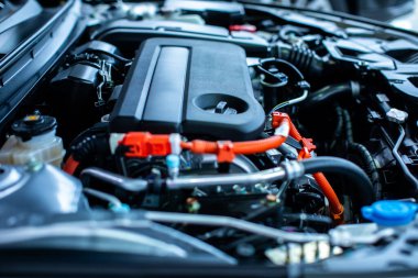 Melez otomotiv endüstrisinin seçici odağı modern araba motor odasının bir parçası, Makine tüm parçalarını ve açık kaputu gösteriyor. Yeni arabanın motor ve elektrikli motor odası. Yeni Araç Motoru.