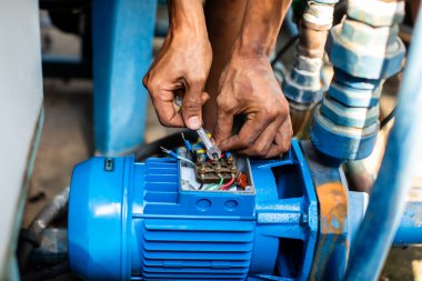 Tesisatçı onarımı ve santrifüj su pompasının motoru için seçmeli odaklanma. Tesisatçılar santrifüj su pompası motoru kurmaya çalışıyorlar. Onarılıyor.