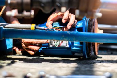 Tesisatçı onarımı ve santrifüj su pompasının motoru için seçmeli odaklanma. Tesisatçılar santrifüj su pompası motoru kurmaya çalışıyorlar. Onarılıyor.