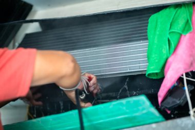 Teknisyenlerin elindeki yüksek basınçlı su spreyine seçici odaklanma ile soğutma bobinlerinin havalandırma panelini temizleyin. Temizlik Servisi.