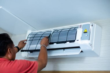 Klima teknisyeni havalandırma için toz filtresini monte ediyor. Temizlik Servisi