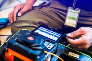 Fiber optik kablo birleştirme araçlarına seçici odaklanma. İnternet kablosu tamir ediliyor. Teknisyen inşaat alanında fiber optik kablo kaynaklıyor. kurulum ya da tamir kablosu.