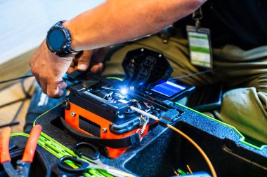 Fiber optik kablo birleştirme araçlarına seçici odaklanma. İnternet kablosu tamir ediliyor. Teknisyen inşaat alanında fiber optik kablo kaynaklıyor. kurulum ya da tamir kablosu.