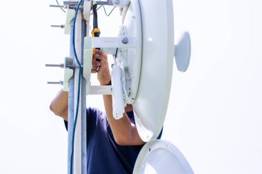 Wi-Fi sinyal çanak sistemini yüklemek için bağlanan fındıkları sıkan mühendislerin ellerine seçici odaklanma.