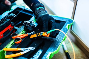 Fiber optik kablo birleştirme araçlarına seçici odaklanma. İnternet kablosu tamir ediliyor. Teknisyen inşaat alanında fiber optik kablo kaynaklıyor. kurulum ya da tamir kablosu.