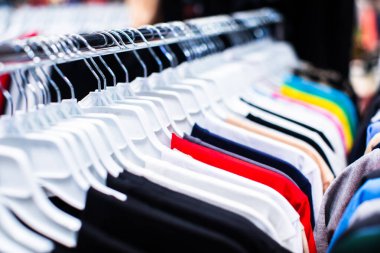 Bit pazarında kullanılmış giysiler asılıydı. Askıda asılı kıyafet koleksiyonu.