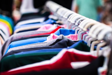 Bit pazarında kullanılmış giysiler asılıydı. Askıda asılı kıyafet koleksiyonu.