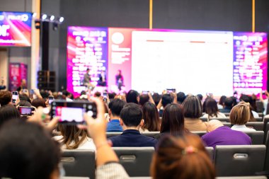 Seçici odak noktası bulanık olan kameraman ve video kamera konferans salonunda ya da seminer salonunda konuşmacı ve seyirciyi kaydetmeye ayarlı. Sergi fuar merkezi. Kitle iletişim aracı kavramı.