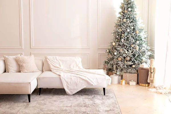 現代的なインテリアでグレーカーペットと明るい部屋のインテリアに3つのクッションと毛布立って快適なソファ 大きなライトコーナーソファとクリスマスツリーとモダンなインテリアリビングルーム ロイヤリティフリーのストック画像