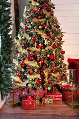 Dekorasyonlu Noel ağacı ve hediyelerle dolu bir oturma odası. Akşamları pırıl pırıl çelenkleri olan Xmas ağacı. Evde Noel. Yeni yıl kış evi dekorasyonu. 