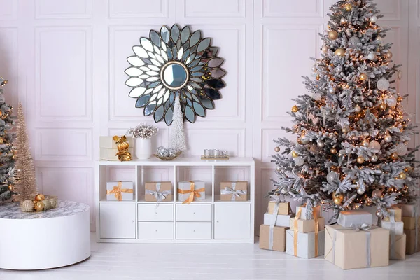 新年家居装饰 墙上挂着一面像太阳一样的圆形镜子 风格别致的白色客厅内部装饰着圣诞树和木制架子与节日装饰 许多礼物 圣诞节在家里 — 图库照片
