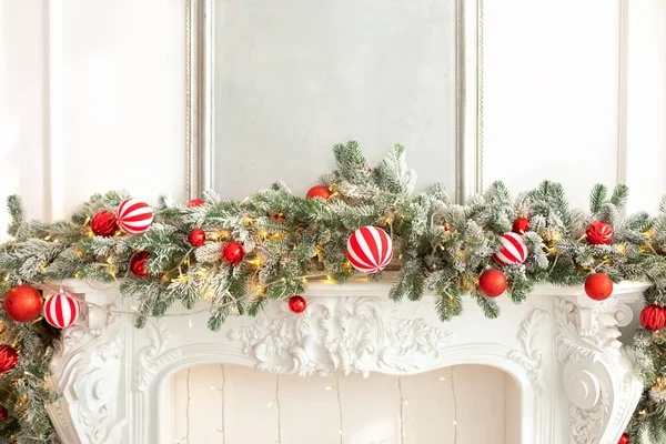 圣诞树 壁炉上有五彩缤纷的节日装饰品 家里壁炉的圣诞装饰品 云杉树枝 玩具和红色球在白色壁炉上 农历新年 — 图库照片