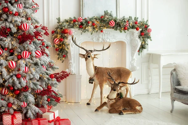 节庆客厅的内部装饰壁炉和装饰鹿角 圣诞节在家里 新年家居装饰 云杉树枝 玩具和红色球在白色壁炉上 农历新年 — 图库照片