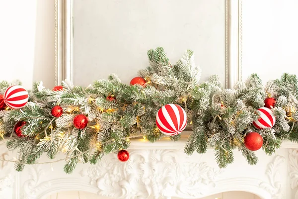 圣诞树 壁炉上有五彩缤纷的节日装饰品 家里壁炉的圣诞装饰品 云杉树枝 玩具和红色球在白色壁炉上 农历新年 — 图库照片