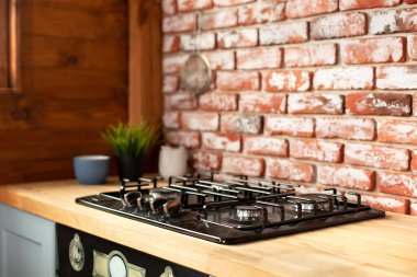 Cozy place for cooking concept. Modern household appliances. Wooden blue kitchen in interior at home with modern furniture, gas stove and oven appliance. 