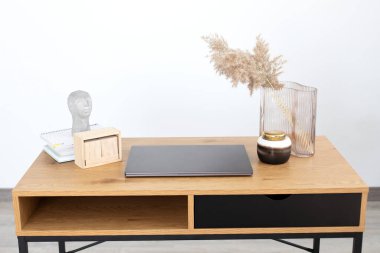 İç çalışma alanı, boş ekran, dizüstü bilgisayar, kurumuş çiçekli vazo ve kafa şekli olarak heykel. Moda dekorlu modern masa, kopyalama alanı. Şık ve rahat yaratıcı iş yeri.