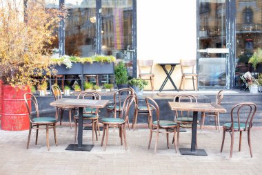 Masaları ve tahta sandalyeleri olan boş bir kafe. Lokantanın klasik dış yüzeyi. Avrupa 'daki kahve dükkanı için mobilya. Kafe masaları olan tipik Paris caddesi manzarası