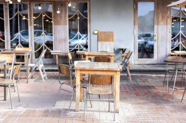 Masaları ve tahta sandalyeleri olan boş bir sokak kafesi. Lokantanın klasik dış yüzeyi. Avrupa 'daki kahve dükkanı için mobilya. Kafe masaları olan tipik Paris caddesi manzarası