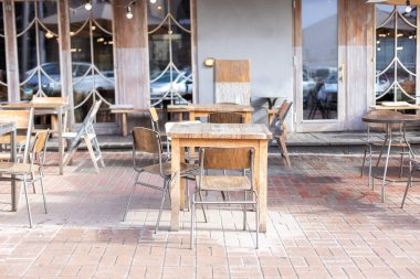 Masaları ve tahta sandalyeleri olan boş bir sokak kafesi. Lokantanın klasik dış yüzeyi. Avrupa 'daki kahve dükkanı için mobilya. Kafe masaları olan tipik Paris caddesi manzarası