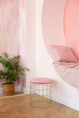 Modern oturma odası tasarımı. Pembe duvarda yastık ve ekoseli dekoratif kemer var. Memphis tarzı iç mekan, kemer ve koltuk için puf. Modern tarz kavramsal iç mekan