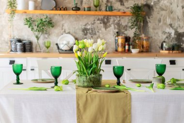 Lale çiçekleri ve cam vazoda yosunlu şenlik ortamı. Düğün masası dekorasyonu. Masada koşucu, oturma odasında şarap kadehi ve tabaklar olan güzel servis masası. 