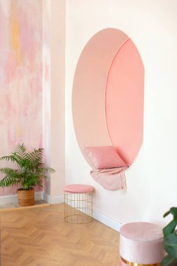 Modern oturma odası tasarımı. Pembe duvarda yastık ve ekoseli dekoratif kemer var. Memphis tarzı iç mekan, kemer ve koltuk için puf. Modern tarz kavramsal iç mekan