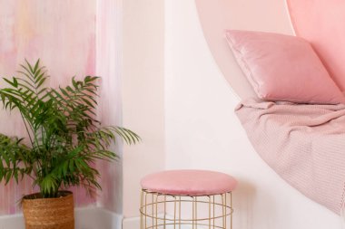 Modern oturma odası tasarımı. Pembe duvarda yastık ve ekoseli dekoratif kemer var. Memphis tarzı iç mekan, kemer ve koltuk için puf. Modern tarz kavramsal iç mekan