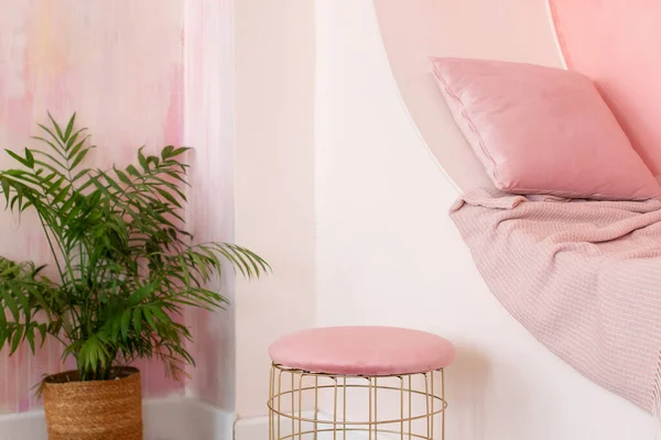モダンなリビングルームは枕と平らなピンクの壁に装飾的なアーチが付いている活気に満ちたインテリアを設計します 座席のためのニッチアーチとポーフが付いているメンフィス様式のインテリア モダンスタイルのコンセプトインテリアルーム ストックフォト