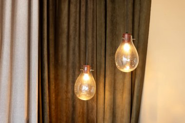 İnce bağcıklı toplar şeklinde modern şeffaf cam lambalar. Tavandan sarkan klasik ampuller. Çatı katındaki cam lambalar. Minimum tavan arası. Ev ya da restoran için Edison ampulleri