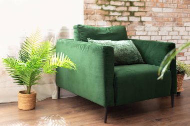 İç dizayn. Yüzyılın ortalarında. Mobilyaları evde. Zarif modern oturma odası. Çatı katı tarzı. Tuğla duvarın yanında yeşil koltuk var.. 