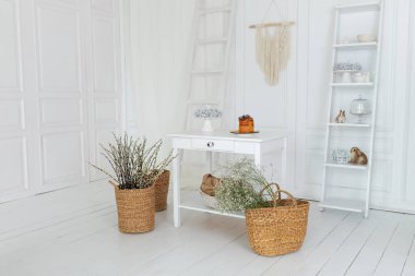 Paskalya sade ev dekorasyonu. Dalları söğüt çiçeği olan hasır sepet. Ahşap masada paskalya pastası. Beyaz mutfağın iç tasarımında bahar skandi dekoru. Kaynak