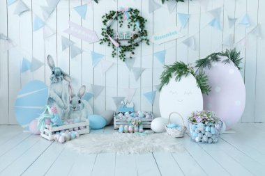 Renkli Paskalya yumurtası ve havuçlu sepetler! Tatil bayrakları ve duvarda bayram çelenkleri. Bahar tarzında çocuk odası. Renkli Paskalya Odası iç tasarımı dekoratif figürlü tavşan veya tavşan. 