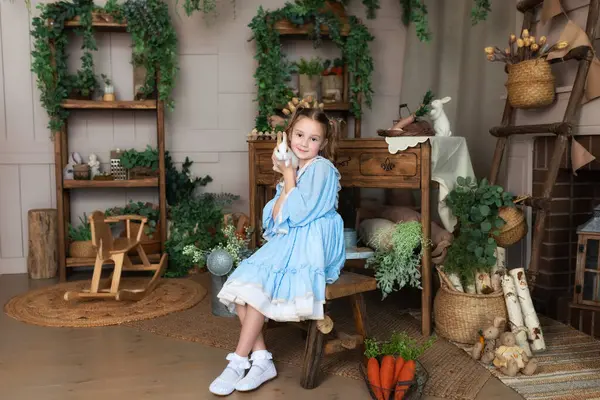 Tavşanla oynayan gülümseyen genç kızın yakın portresi. Küçük mutlu kız, sevimli, tüylü bir paskalya tavşanı tutuyor. Bunny ile arkadaşlık. Sevimli Çocuk ve Hayvan. Küçük Çiftçi. Hayvan sevgisi konsepti