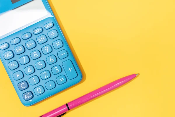 stock image Flat lay of Calculator and pen on yellow background. Vibrant colors Copy space