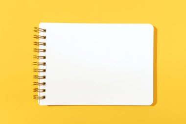 Sarı arka planda izole edilmiş boş kağıt defter. Şablon maketi