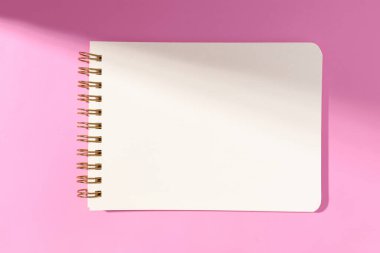 Pembe arka planda izole edilmiş boş beyaz kağıt defter. Şablon maketi