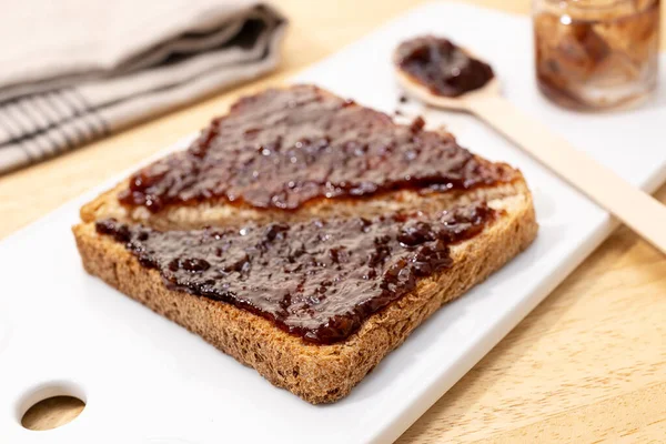 Close up of whole wheat bread Toast sandwich and raspberry organic jam on wooden table. Selective focus