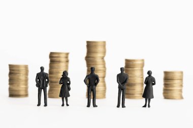 Bir grup heykel bozuk para yığınlarına bakıyor. Beyaz arka plan. Uzayı kopyala İş ya da ekonomi kavramı