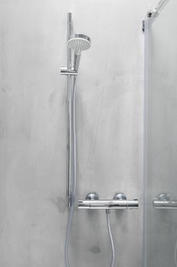 Duş başlığı ve sıcaklık kontrolü modern bir banyonun gri mikroçipinde.