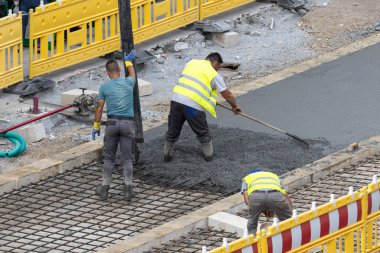 Galiçya, İspanya; 20 Temmuz 2023: Bir inşaat sahasına beton döken işçiler