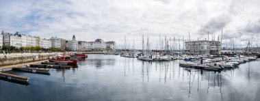 Coruna, İspanya; 29 Ağustos 2023: Panoramik manzara Bir Coruna deniz sporları limanı ve bulutlu bir günde şehrin modernist binaları