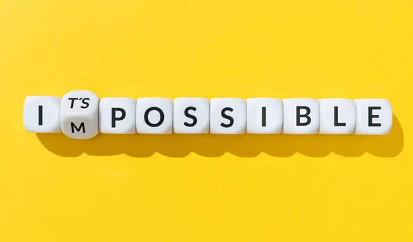Changing word impossible into it is possible. Cube blocks with text isolated on yellow background