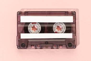 Pembe arka planda izole edilmiş boş etiketleri olan eski kaset, şablon maketi