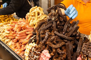 İspanyol sokak pazarında lezzetli churro ve çikolata servisi yapan bir sokak satıcısı.