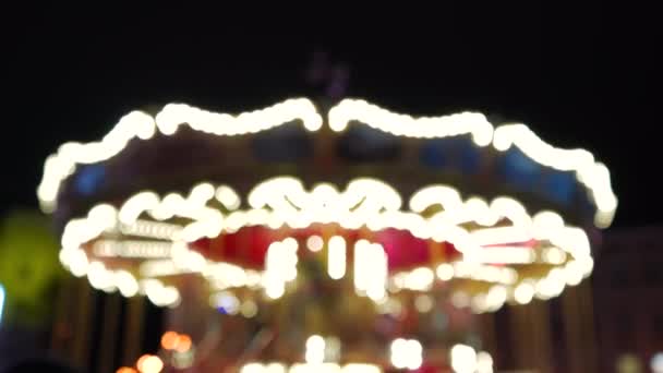 令人难以置信的五彩斑斓的光芒在一个游乐园里的一个古老的嘉年华华丽的旋转木马 背景上模糊不清的灯光 — 图库视频影像