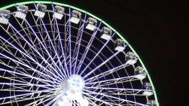 Ukrayna. Kyiv. 12.2021: Kyiv 'de kış gecesi aydınlanmış dönme dolap. Yerde kar yığınları var. Yeni yıl atmosferi